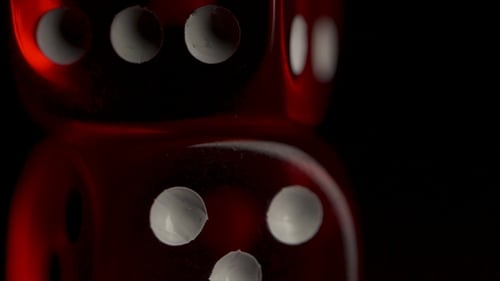 Zwei rote Casino-Würfel auf schwarzem Hintergrund.