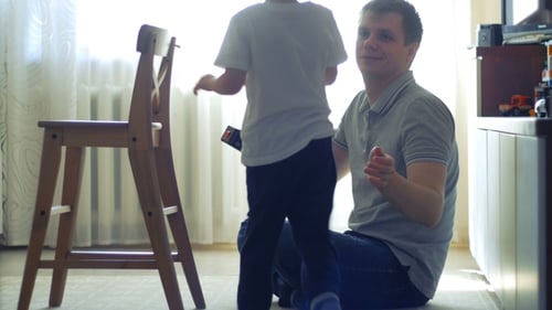 Father and Child Assembling Wooden Chair Together