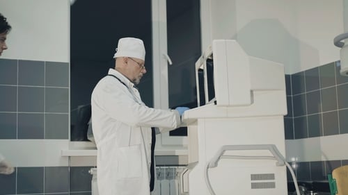 Doctors Operating Medical Device in Hospital Room