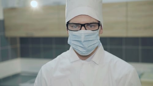 Portrait of the Young Doctor in Uniform Looks at Camera