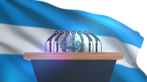 Press Conference Podium with Microphones and Waving Flag