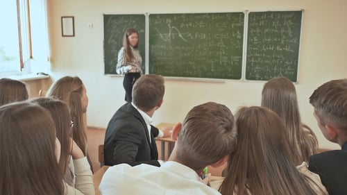 Teacher Explains Equations to Young Adult Students