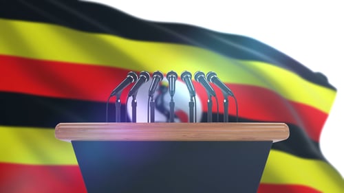 Uganda Flag Waving Behind Podium with Microphones