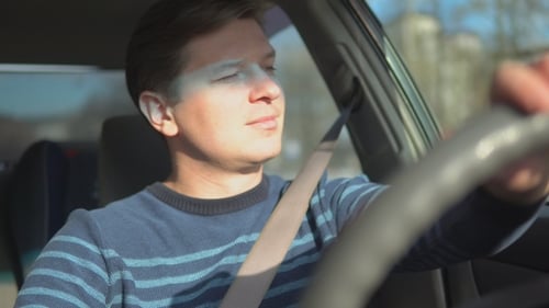 Man Driving Car Wearing Seatbelt on Sunny Day