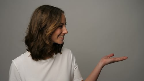 Smiling Woman Presenting With Her Hand Open