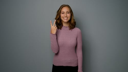 Smiling Young Woman with Peace Sign Gesture
