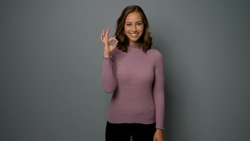Smiling Woman Making OK Hand Gesture