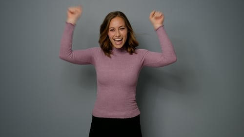 Smiling Woman Posing in Front of Gray Background