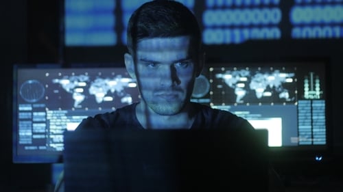 Focused man using laptop with coding on screens