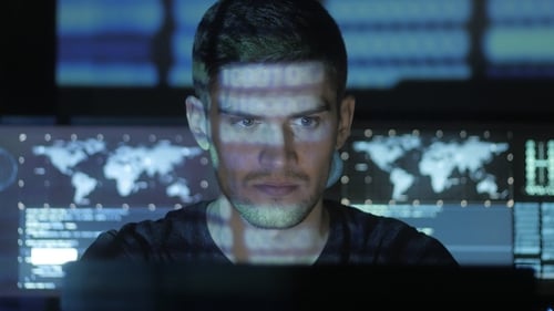 Intense man working at computer, data on face