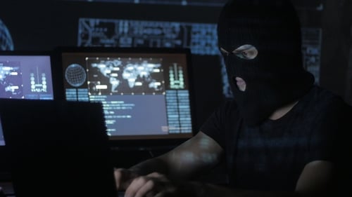 Gefährlicher Hacker in der Maske versucht mithilfe von Codes und Zahlen in das System einzudringen, um herauszufinden,