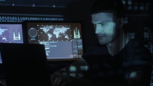 Man Typing Code in Dark Futuristic Room