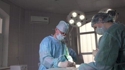 Doctors performing operation in sterile hospital setting