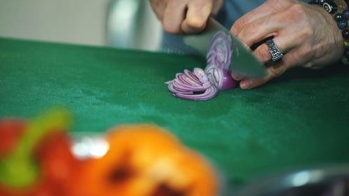 Hand Slices Fresh Red Onion With Sharp Knife