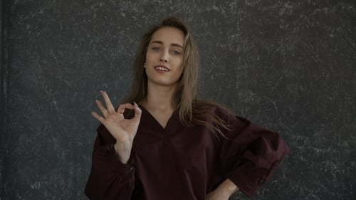 Young Adult Woman Makes OK Gesture