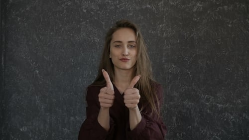 Woman Gives Two Thumbs Up and Smiles
