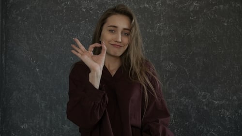 Young Woman Gives Okay Sign of Approval