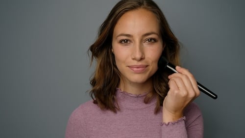 Woman Applying Makeup with Brush Close Up