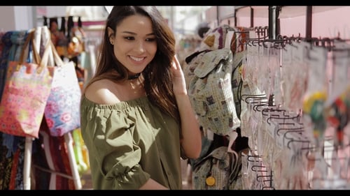 Woman Shops at Outdoor Market for Accessories