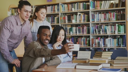Cheerful Friends Taking Selfie in University Library