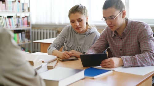 Jeunes étudiants travaillant ensemble à l'aide d'une tablette