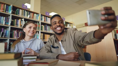 Two Students Taking Selfie Together in Library