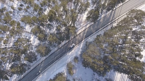 Snowy Road with a Moving Cars in Winter