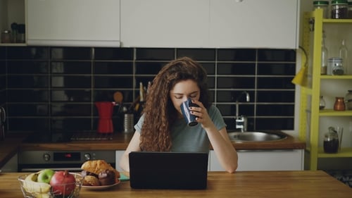 Young Couple Using Laptop in Kitchen Together