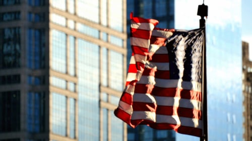 Tattered American Flag Waving in Urban Setting