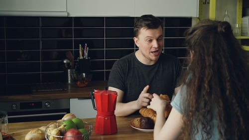 Couple Chatting Over Breakfast in the Kitchen