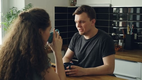 Couple Chatting over Coffee in Bright Kitchen