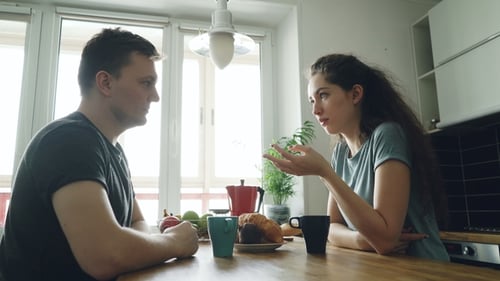 Couple Talking at Kitchen Table in Natural Light