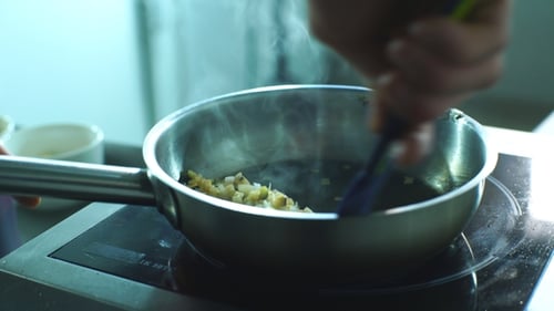 Food Cooking in Pan on Stove Top