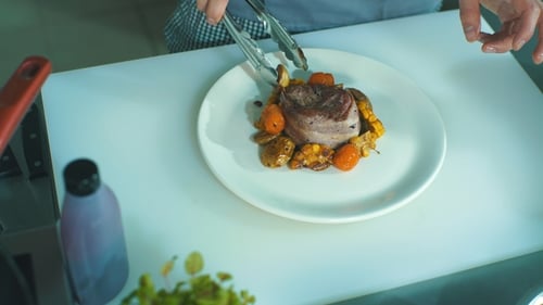 Chef Plates Gourmet Meat Dish with Vegetables