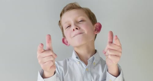 Close-up Portrait. A Boy Is Snapping with Both Hands, Shaking His Head "Yes".
