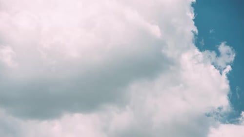 Dramatic Clouds Drifting Across The Bright Blue Sky