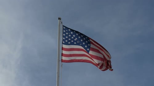 American Flag Waving Proudly Against Blue Sky