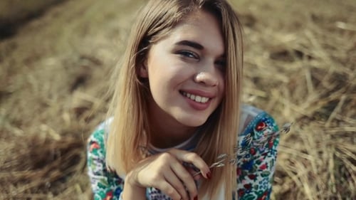 View of a Beautiful Girl in a Traditional Embroidered Shirt Sitting on a Stack of Hay