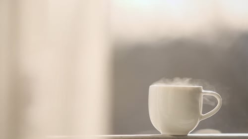 Eine rauchende Tasse heißen Tees am Fenster Seite abstrakte Unschärfe Hintergrund