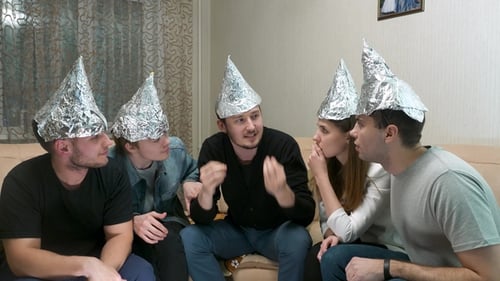 Group of People with Foil on Their Heads Discussing Conspiracy Theories. Friends with Foil on Their