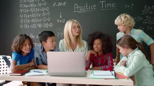 Happy Diverse School Children Students Gather at Teacher Table Look at Laptop