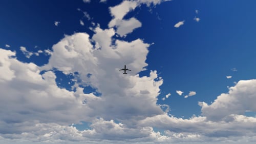 Jet Aircraft Flying Overhead Through White Clouds in Blue Sky