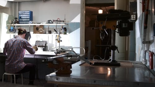 Back View of Professional Welder Man with Torch and Protective Mask Welding Steel with Spark in