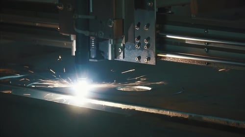 Industrieller Laserschneider mit Funken. Clip. Der programmierte Roboterkopf schneidet mit Hilfe eines riesigen