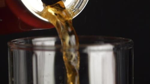 Pouring Glass of Soda Drink. . Pouring of a Brown Beverage From a Aluminum Bottle