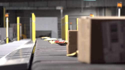 Grande quantidade de pacotes sendo transportados em correias transportadoras