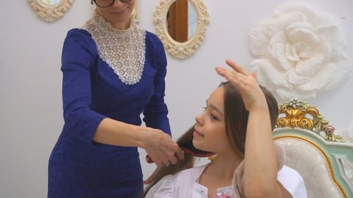 Woman Brushing Child's Hair at Home
