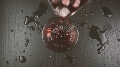 Mit Wasser und Eis verdünnter Rotwein wird in ein Glas gegossen