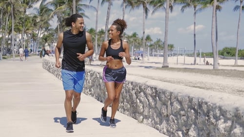 Couple ethnique interagissant pendant le jogging