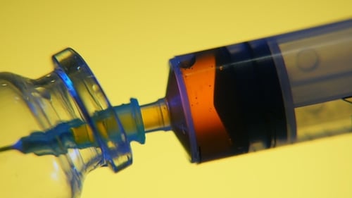 Sangue vermelho é sugado para uma seringa de um tubo de ensaio em um laboratório médico